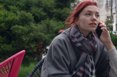 Terasta telefonlu bir kadın var.