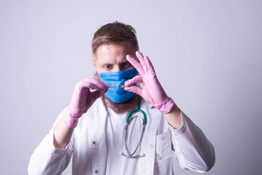 Maskeli genç bir doktor elinde inzulin şırıngası tutuyor.