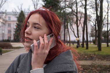 Terasta telefonlu bir kadın var.