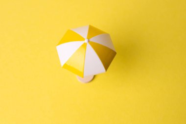 Yeşil arka planda renkli plaj şemsiyesi