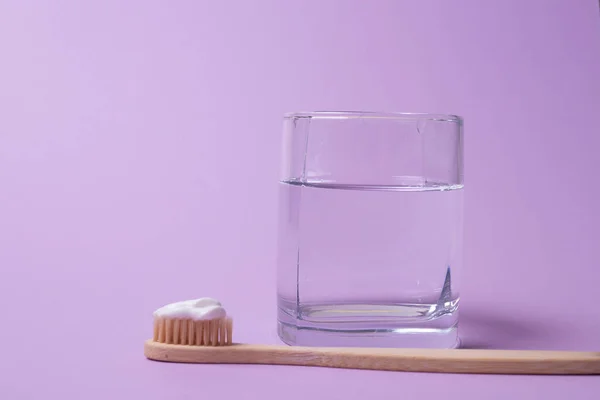 Tahta diş fırçası ve bir bardak su.