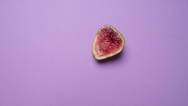 Olgun bir incir meyvesi ikiye bölünmüş.