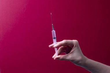 Kadın eli tıbbi şırınga tutuyor.