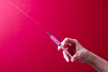 Kadın eli tıbbi şırınga tutuyor.