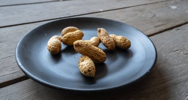 Arachis hipogaea, siyah tabakta yer fıstığı, ahşap zemin.