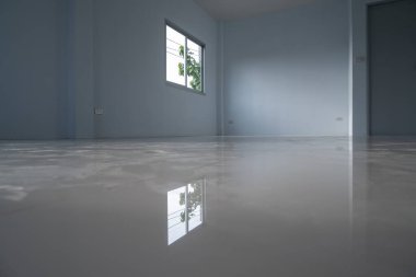 Pencereleri, döşemeleri, yansımaları, ağaçları olan bir oda..