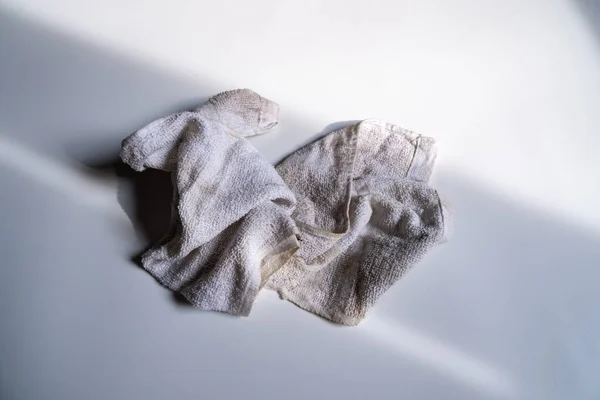 Lekeleri silmek için bir bez. Lekelenene kadar kullanılıyor. Beyaz bir arka planı var.,