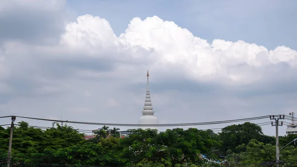 Gökyüzünün arkasındaki büyük bir ağaçtan çıkan bir tapınak bulutlarla doludur..