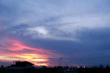 Yağmurdan önce, şehrin üzerinde gün batımını izliyorum.