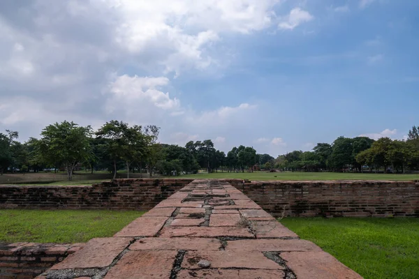 Tuğla yolu ve gökyüzünün arkasındaki Ayutthaya eski kenti turistik bir ilgi odağı..