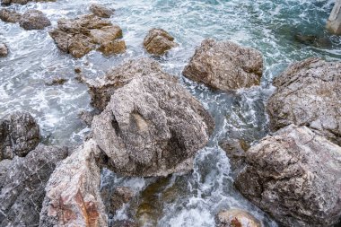 Deniz kenarındaki birçok büyük kaya dalgalar tarafından aşınıyor, çeşitli şekillerde..