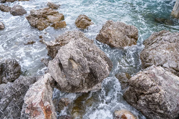 Deniz kenarındaki birçok büyük kaya dalgalar tarafından aşınıyor, çeşitli şekillerde..