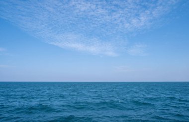 Deniz ve gökyüzü paralel, yüzen beyaz bulutlardır..