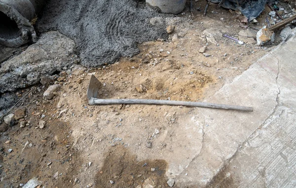 A shovel with a wooden handle, as a digging tool, or used in construction.