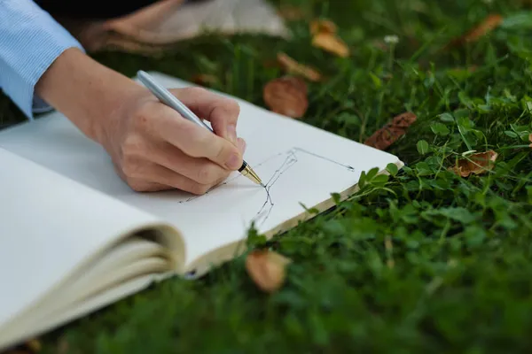 Deftere yazı yazan kadın elleri, dış mekan işçisi, uzaktan çalışma.