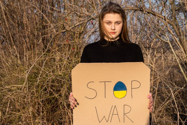 stock image Angry Ukrainian girl  protesting war conflict raises banner with inscription massage text on map 