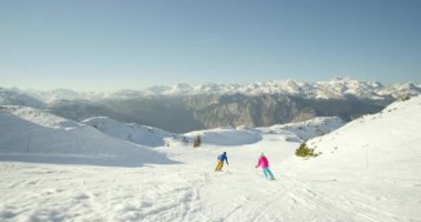 Karlı dağlarda kayak yapan adam ve kadın