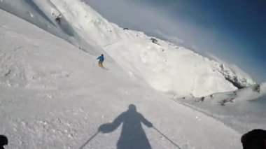 Karlı dağlarda kayak yapan adam ve kadın