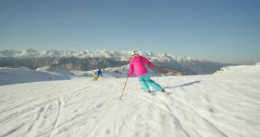 Karlı dağlarda kayak yapan adam ve kadın