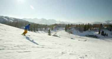 Karlı dağlarda kayak yapan adam ve kadın