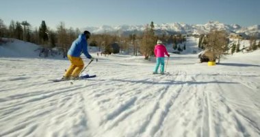 Karlı dağlarda kayak yapan adam ve kadın