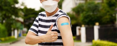 Man showing thumbs up after vaccination clipart