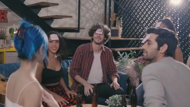 Friends enjoying game with beer bottles at home party — Videoclip de stoc