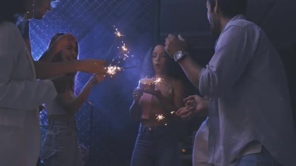 Friends celebrating with cake and sparklers in party — Wideo stockowe