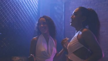 Gençler gece kulübünde eğleniyor ve kadeh kaldırıyor.