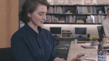 İş arkadaşları çalışırken dijital tablet kullanan güzel beyaz bir kadın.