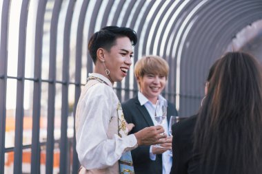 Genç iş adamları birbiriyle kadeh kaldırıyor ve çatılarda dururken gülümsüyor.