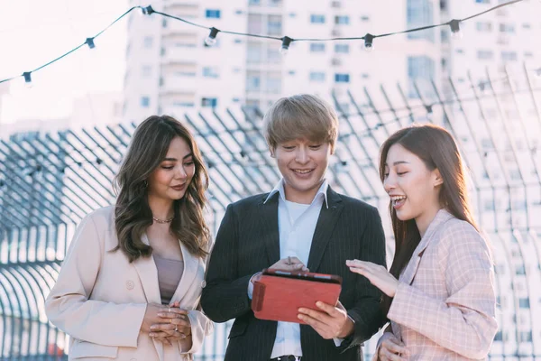 Gente de negocios asiáticos trabajando juntos y utilizando una tableta digital. Grupo de profesionales discutiendo al aire libre — Foto de Stock