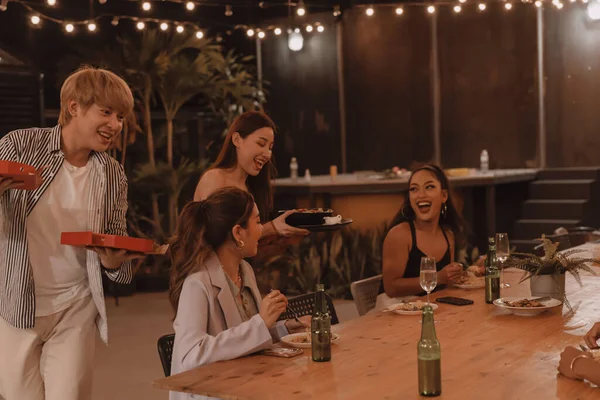 Jóvenes amigos asiáticos comiendo y disfrutando de la cena juntos en el restaurante al aire libre. Celebración de amistad y reunión —  Fotos de Stock