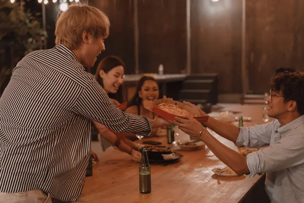 Jóvenes amigos asiáticos comiendo y disfrutando de la cena juntos en el restaurante al aire libre. Celebración de amistad y reunión —  Fotos de Stock