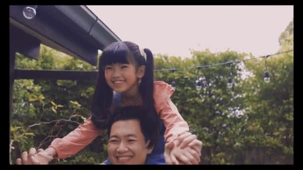 Young Asian father giving his daughter piggyback and smiling in front of house — Stock Video