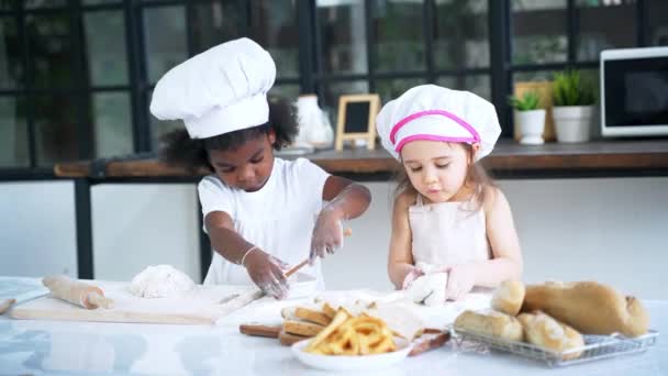 Diverso grupo de chicas preparan la masa y hornear galletas en la cocina — Vídeos de Stock