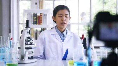 Laboratuvarda tıbbi araştırma ve bilim deneyleri üzerine çevrimiçi video dersi alan kadın.