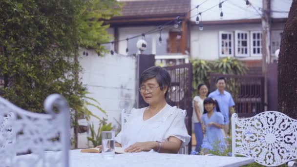 Young Asian girl running to grand mother and hugging at home while parents greeting with wai gesture — Αρχείο Βίντεο