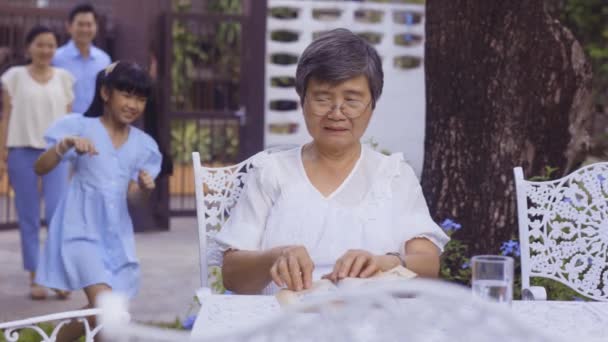 Young Asian girl running to grand mother and hugging at home while parents are watching — 图库视频影像