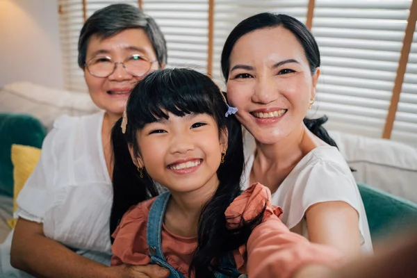 Asian girl taking selfie with female relatives — стоковое фото