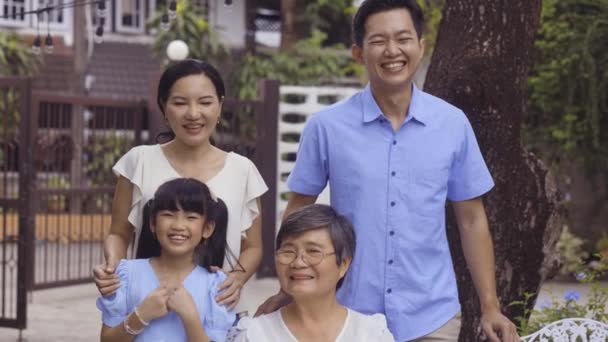 Asian multi generational family looking at camera and smiling at home — Stockvideo