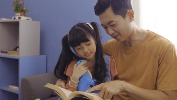 Father and daughter reading book together — Stock Video