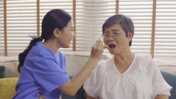 喂老年妇女的亚洲护士 — 图库视频影像