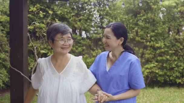 Asiatisch krankenschwester und patient walking im hinterhof — Stockvideo
