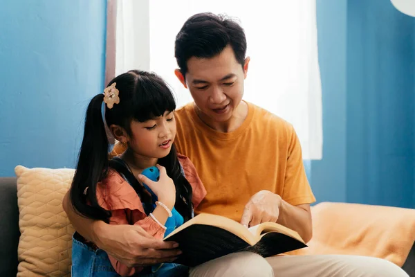 Asiático Papá Abrazando Hija Leyendo Cuento Hadas Libro Mientras Sentado — Foto de Stock