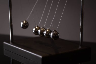 Closeup metal Newton beşiği momentum kavramı gösterimi olarak gri arka plan üzerine yerleştirilen