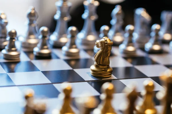Zlatý Rytíř Umístil Proti Mnoha Stříbrným Šachovým Figurům Šachovnici Obchodníkem — Stock fotografie
