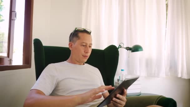 Detailní Záběr Mladého Muže Čtení Digitálním Tabletem Zatímco Sedí Pohovce — Stock video