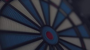 A dart hitting the center of target in dramatic light and shadow. Bullseye target or a dart dashboard for financial business planning and targeting with winner goal concept