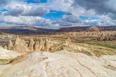 Peri bacalarının panoramik görüntüsü ve bulutlu bir günde Goreme, Kapadokya, Türkiye yakınlarındaki tipik kaya oluşumları